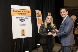 Melissa Cook, Mission Office Manager, accepts the Top Workplaces award